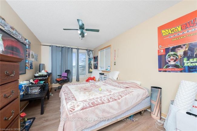 Bedroom with ceiling fan, a textured ceiling, and light wood-type flooring | Image 23