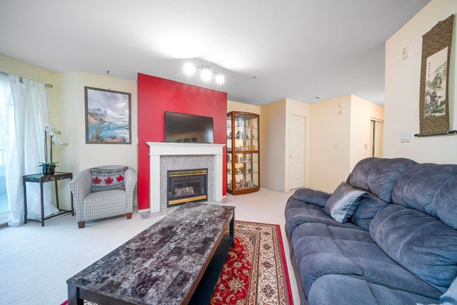 Carpeted living room featuring a tiled fireplace | Image 29