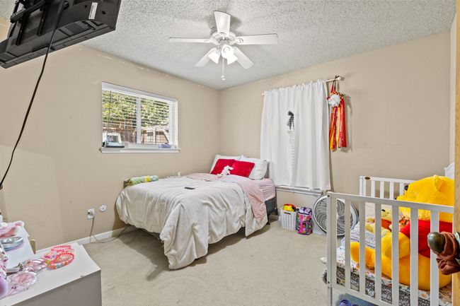Bedroom with carpet floors, a textured ceiling, and a ceiling fan | Image 15