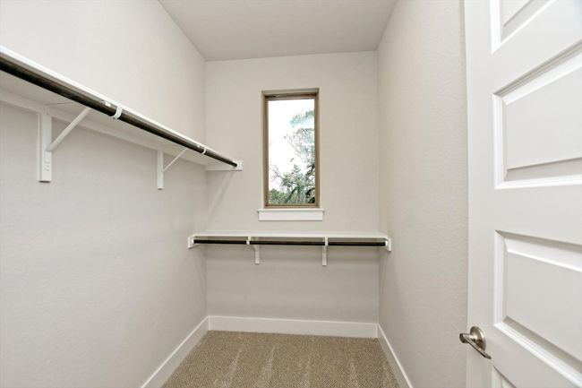 Walk in closet featuring light colored carpet | Image 22