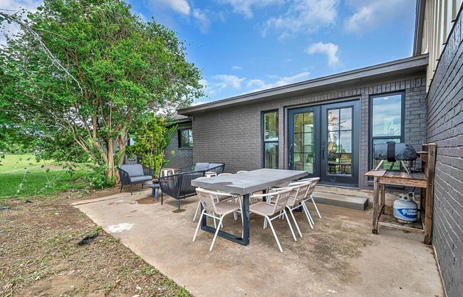 View of back patio / terrace featuring outdoor dining area & firepit area | Image 37