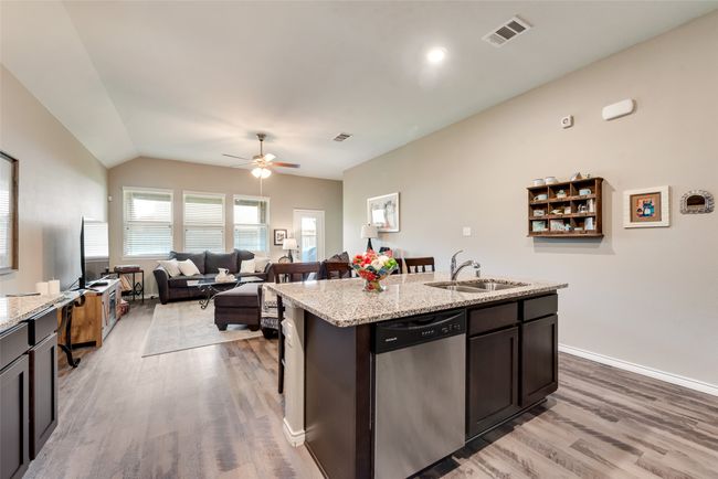 Kitchen with dishwasher, light wood-style flooring, a ceiling fan, open floor plan, and an island with sink | Image 12