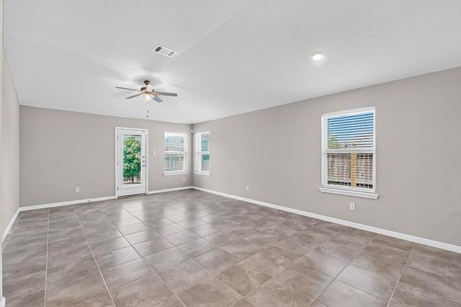 Empty room featuring ceiling fan and tile patterned floors | Image 7