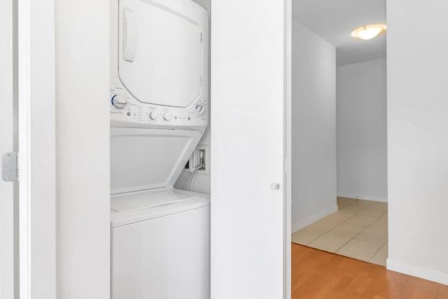 Laundry area with stacked washer / dryer and light wood-type flooring | Image 18