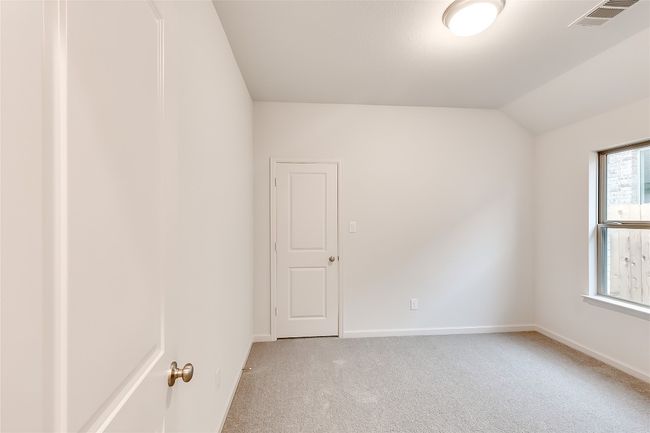 Spare room with light colored carpet, baseboards, and lofted ceiling | Image 24