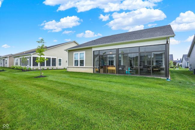 Back view of property featuring a sunroom. Lawn maintenance included with HOA | Image 25
