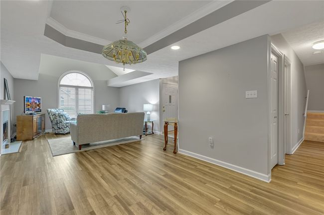Lovely view again of the dining area and living room space. You can see down the hall to the left is a half bath to the right is the master en-suite and the stairs that lead to the spacious upper level bedroom, complete with full bath and walk in closet. | Image 9