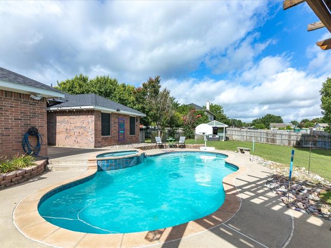View of pool with a patio area and a pool with connected hot tub | Image 32