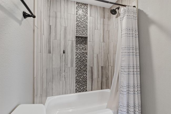 Secondary bathroom also features a tub/shower combo with decorative tile. | Image 24