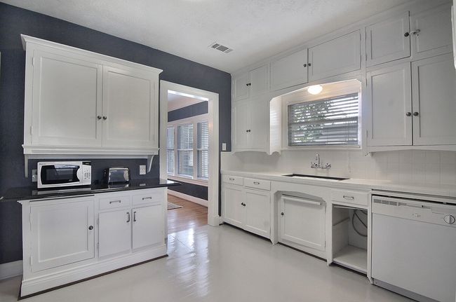 Kitchen featuring visible vents, white appliances, tasteful backsplash, white cabinetry, and a sink | Image 21
