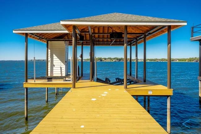 Boathouse offers an extra wide walkway with single slip boat lift, water craft lifts and storage closet. | Image 32