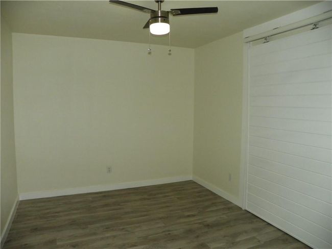 Empty room featuring ceiling fan and dark wood-type flooring | Image 10