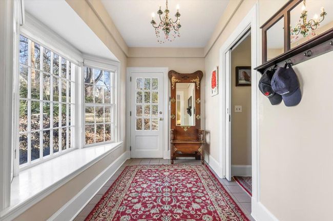 Doorway featuring tile patterned flooring, a notable chandelier, plenty of natural light, and baseboards | Image 7