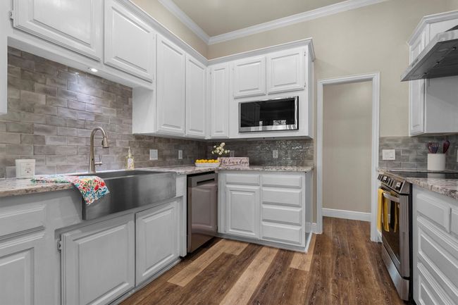 The farm house stainless sink and neutral subway backsplash keep the kitchen stylish and functional! | Image 15