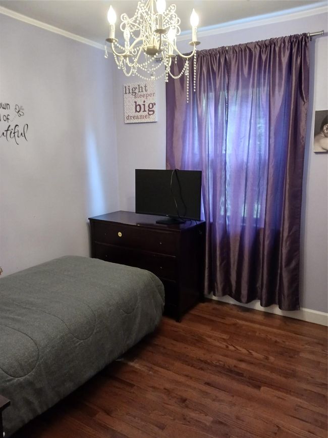 Bedroom featuring ornamental molding, a notable chandelier, and dark wood finished floors | Image 15