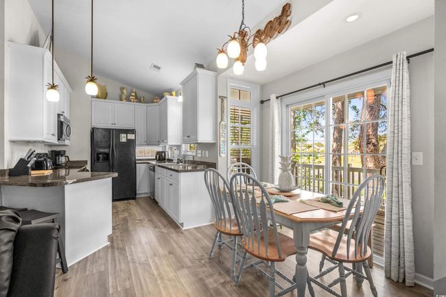 Living area featuring an inviting chandelier, wood finished floors, and high vaulted ceiling | Image 20