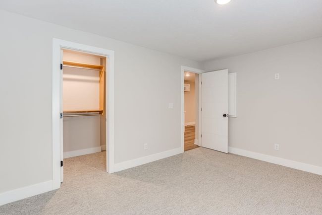 Unfurnished bedroom with a spacious closet, baseboards, carpet floors, a closet, and recessed lighting | Image 26