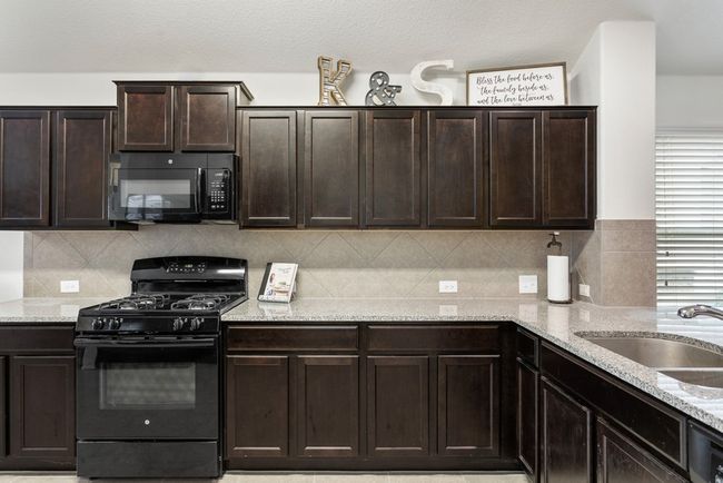 The kitchen offers a breakfast bar perfect for stools, granite countertops, lots of cabinet and work space, and a great dining area! | Image 7