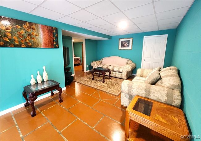 Tiled living room featuring a drop ceiling and baseboards | Image 28