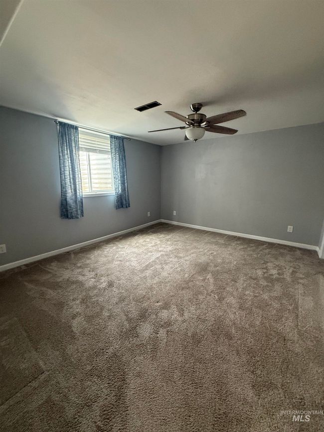 Carpeted spare room featuring a ceiling fan and baseboards | Image 17