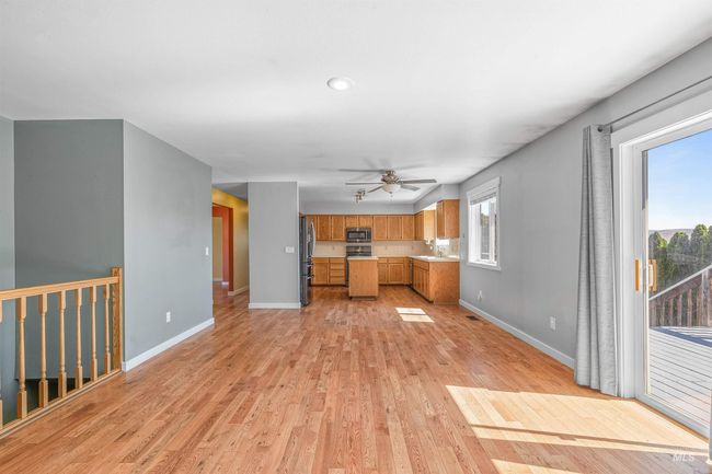 Unfurnished living room featuring light wood finished floors and ceiling fan | Image 7