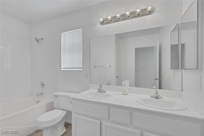 Full bath with double vanity, washtub / shower combination, and wood finished floors | Image 18