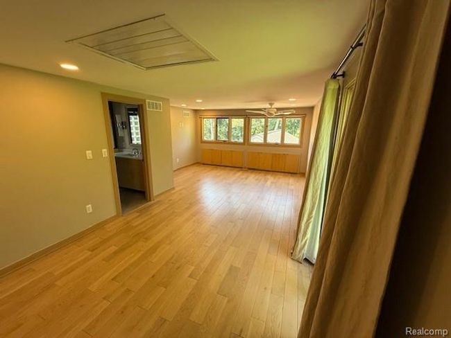Spare room featuring light wood finished floors, recessed lighting, and a ceiling fan | Image 18