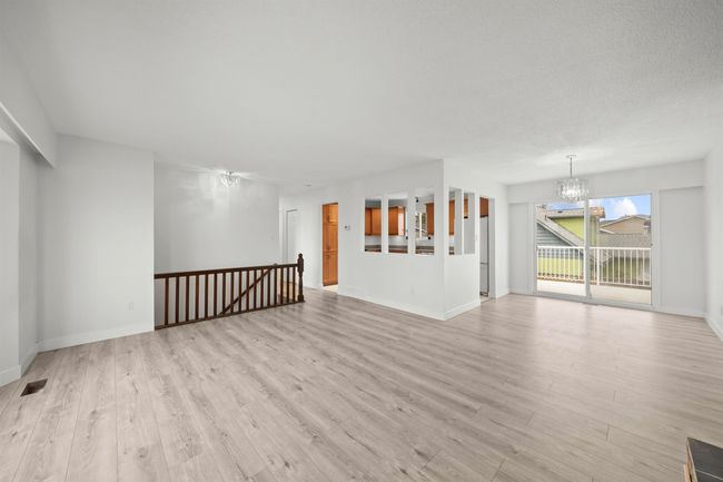 Unfurnished living room featuring baseboards, a notable chandelier, visible vents, and light wood-style floors | Image 8
