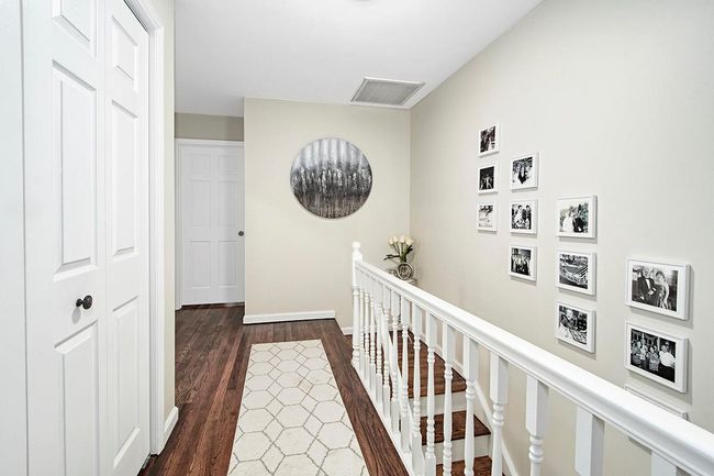 Corridor featuring an upstairs landing, visible vents, baseboards, and dark wood-style flooring | Image 18