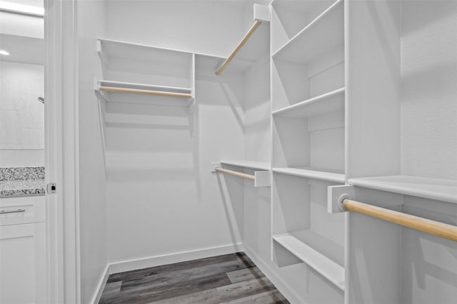 Walk in closet with dark wood-style floors | Image 10