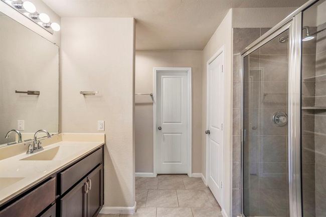 Dual sinks, and a glass enclosed shower are on offer in the en-suite bathroom. | Image 23