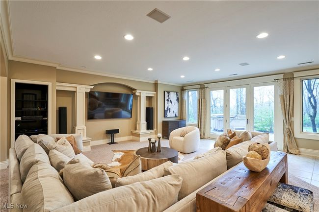 The family room is on the lower level with recessed lighting, decorative columns, crown molding, and sliders leading to back yard and patio. | Image 31