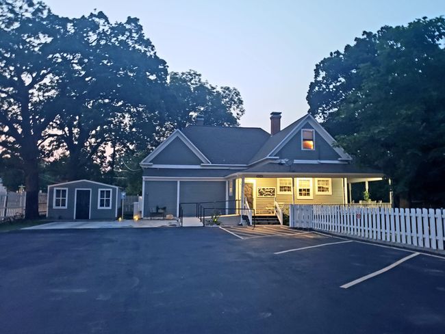 Back of property off of Ollie Street, Featuring asphalt parking lot, t parking for ADA as well as ramp and railing up to wrap around porch cemen | Image 4