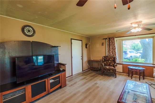 Living room featuring a ceiling fan and light wood-type flooring | Image 18