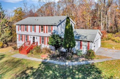 Colonial home featuring a front lawn and a garage | Image 1