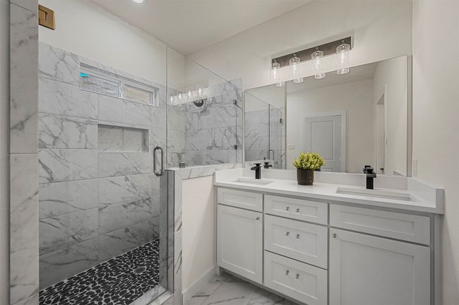 Bathroom featuring a marble finish shower, marble finish floor, a sink, and double vanity | Image 20