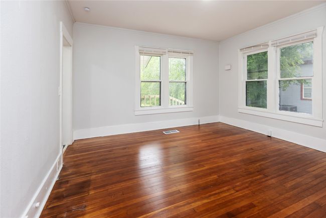 Unfurnished room with healthy amount of natural light, hardwood / wood-style floors, crown molding, and baseboards | Image 33