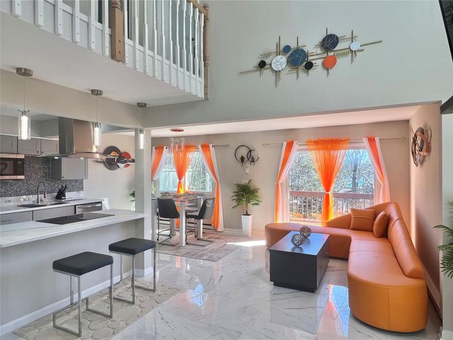 Living area featuring a high ceiling, marble finish floor, and baseboards | Image 29