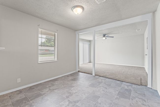 Carpeted empty room with a textured ceiling and a ceiling fan | Image 5