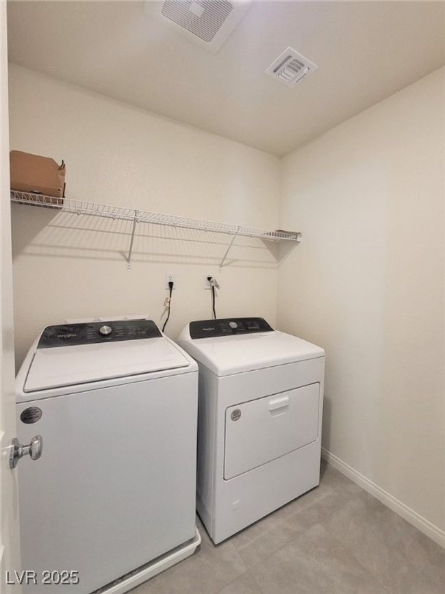 Clothes washing area featuring laundry area, washer and clothes dryer, visible vents, and baseboards | Image 9