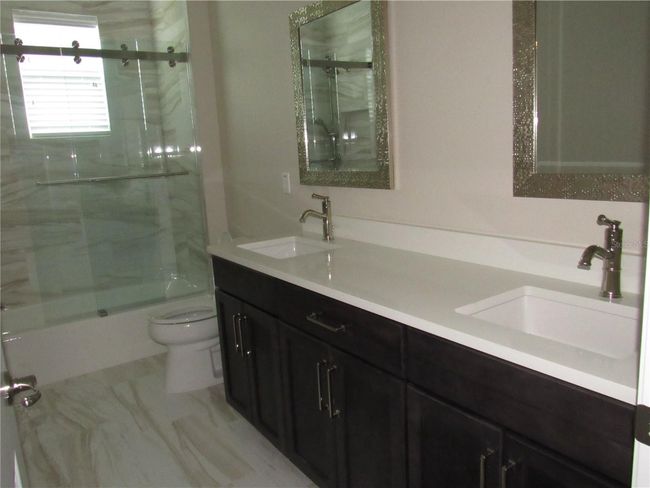 guest bath with tub & shower and dual vanitioes | Image 43