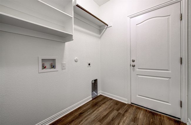 Laundry area featuring dark wood finished floors, electric dryer hookup, washer hookup, and hookup for a gas dryer | Image 9