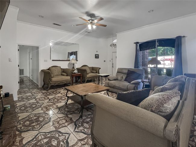 Tiled living area with a ceiling fan | Image 19