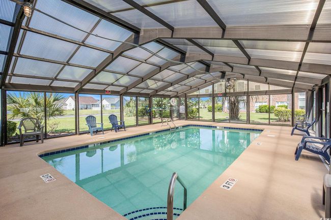 Indoor pool with a patio area and glass enclosure | Image 23