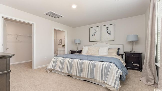 Bedroom featuring light carpet, connected bathroom, a walk in closet, and a closet | Image 15