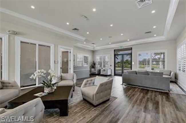 Living area with a tray ceiling, crown molding, wood finished floors, and recessed lighting | Image 30