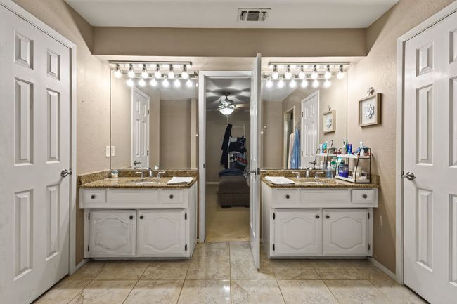 Bathroom featuring ceiling fan, two vanities, and a textured wall | Image 12
