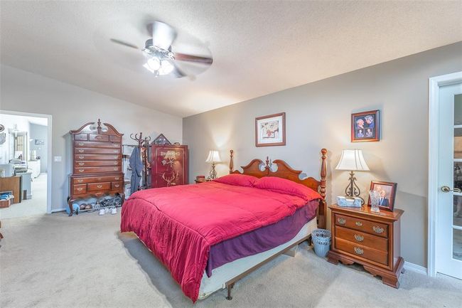 Bedroom with carpet flooring, a ceiling fan, and a textured ceiling | Image 19