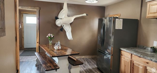 Kitchen with dark wood-style floors, baseboards, stainless steel refrigerator with ice dispenser, and light brown cabinetry | Image 14