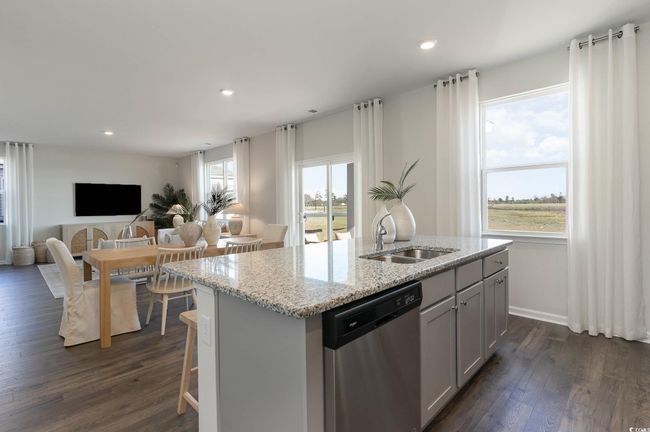 Kitchen featuring a sink, dishwasher, a kitchen island with sink, open floor plan, and dark wood-style floors | Image 8